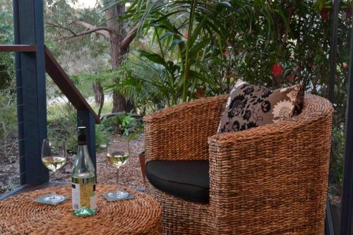 een tafel met een fles wijn en een glas bij Aroha in Margaret River Town