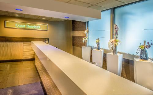a lobby of a restaurant with a long counter at Hotel 116, A Coast Hotel Bellevue in Bellevue