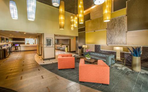 an office lobby with orange chairs and a couch at Hotel 116, A Coast Hotel Bellevue in Bellevue
