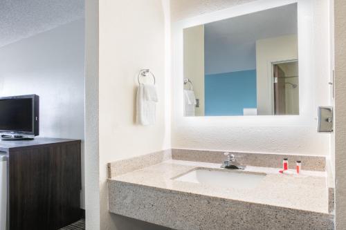 a bathroom with a sink and a mirror at Howard Johnson by Wyndham Scott Lafayette in Scott