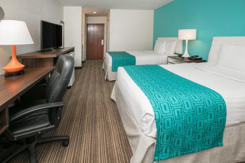 a hotel room with two beds and a desk and a computer at Howard Johnson by Wyndham Scott Lafayette in Scott