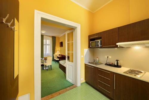 a kitchen with an open door to a living room at Martin Hotel Prague in Prague