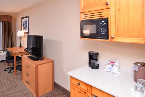 a hotel room with a kitchen with a microwave and a desk at Best Western Plus Olympic Inn in Klamath Falls