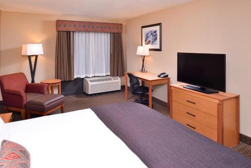 a hotel room with a bed and a flat screen tv at Best Western Plus Olympic Inn in Klamath Falls