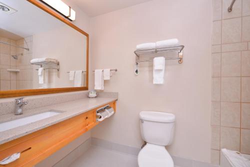 a bathroom with a sink and a toilet and a mirror at Best Western Plus Olympic Inn in Klamath Falls
