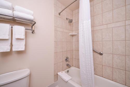 a bathroom with a shower with a tub and a toilet at Best Western Plus Olympic Inn in Klamath Falls