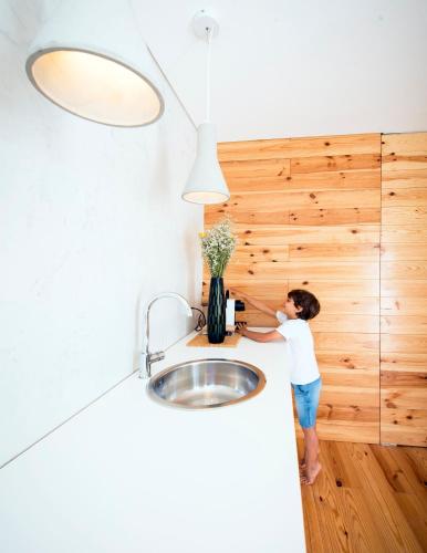 a young boy is standing next to a sink at Cozy Lisbon Graça in Lisbon