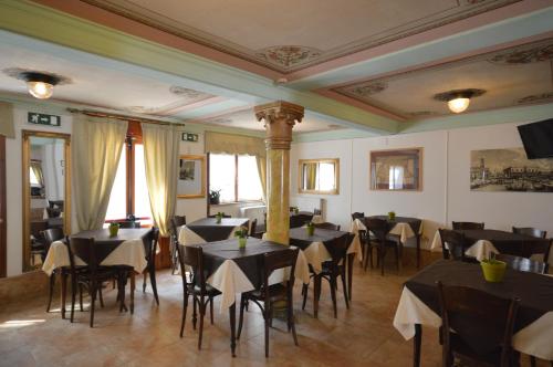 una sala da pranzo con tavoli e sedie neri di Albergo Marin a Venezia