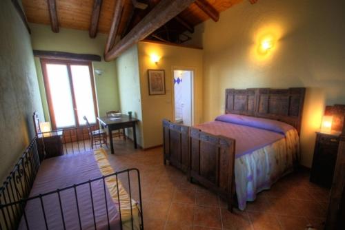 a bedroom with a large bed and a dining room at Azienda Agrituristica Alcastlè in Montabone