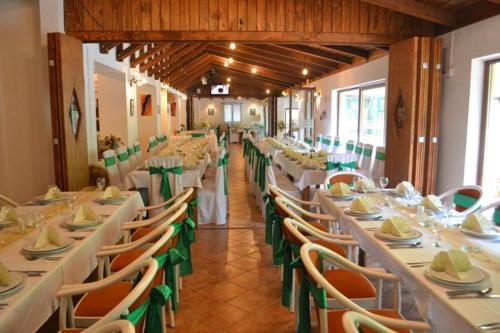 a dining room with white tables and green chairs at Motel Stovrela in Cazin