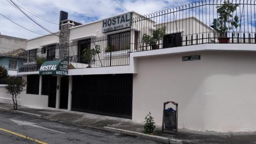 a white building with a balcony on a street at Hostal Santa María Gracia in Quito