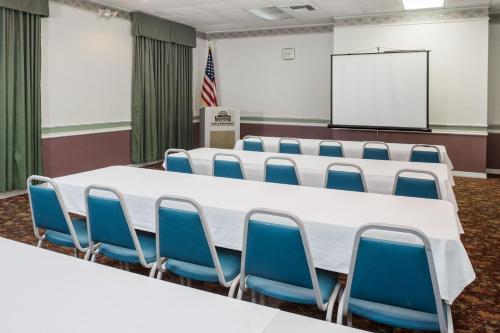 a conference room with a white table and blue chairs at Days Inn & Suites by Wyndham Port Richey in Port Richey