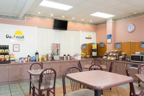 a restaurant with a table and chairs and a counter at Days Inn & Suites by Wyndham Port Richey in Port Richey