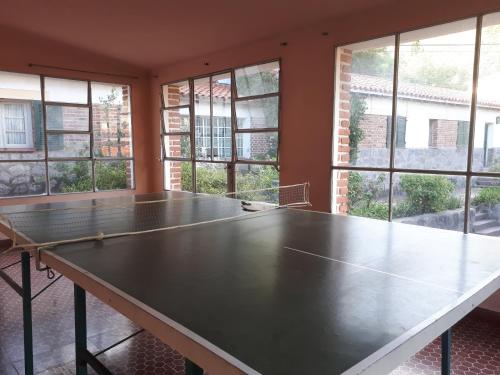 a ping pong table in a room with windows at Hotel Zapata in La Cumbre