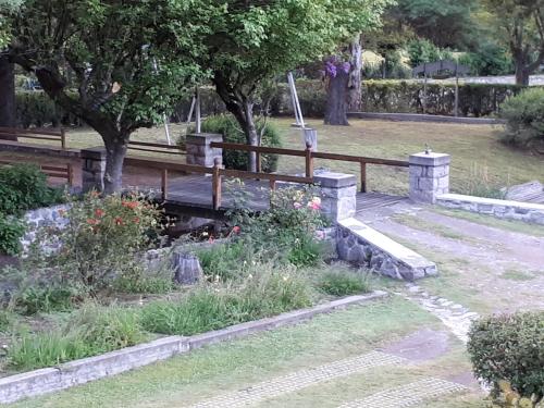 a park with a wooden bench and a waterfall at Hotel Zapata in La Cumbre