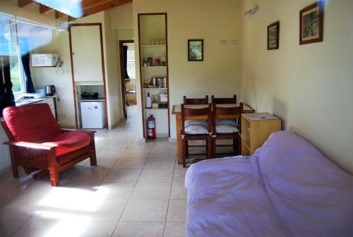 a living room with a couch and a table and chairs at Cabañas Del Hain in Ushuaia