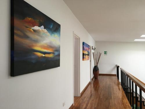 a hallway with a large painting on the wall at Regine's Manizales By Hoteles Confort 80 in Manizales