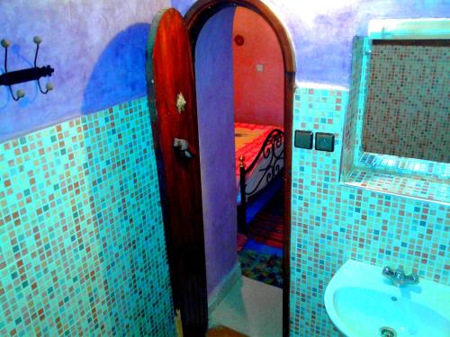 La salle de bains est pourvue d'un lavabo et d'un lit dans la chambre. dans l'établissement Auberge Kasbah Tiriguioute, à Skoura