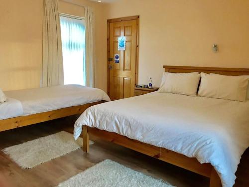 1 dormitorio con 2 camas y ventana en Clogher Valley Golf Club, en Fivemiletown