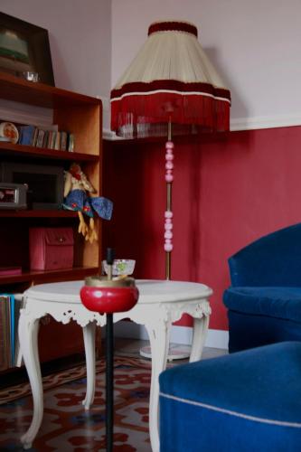 a living room with a white table and a blue chair at Maison Decò in Catania