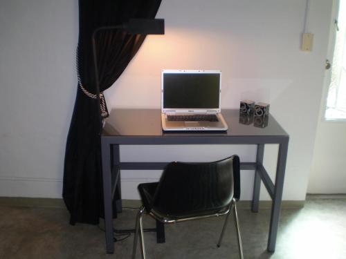 a desk with a laptop computer on it with a chair at Palermo Viejo Bed & Breakfast in Buenos Aires
