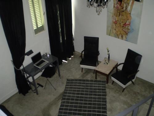 a living room with chairs and a table and a table and chairsktop at Palermo Viejo Bed & Breakfast in Buenos Aires