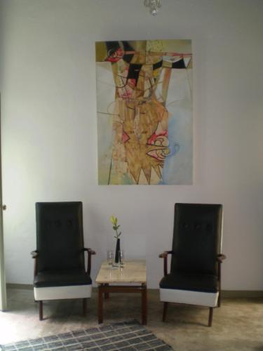 two chairs and a table with a painting on the wall at Palermo Viejo Bed & Breakfast in Buenos Aires