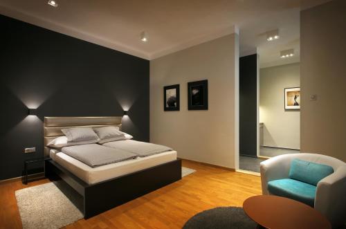 um quarto com uma cama e uma cadeira em Gateway Budapest City Center em Budapeste