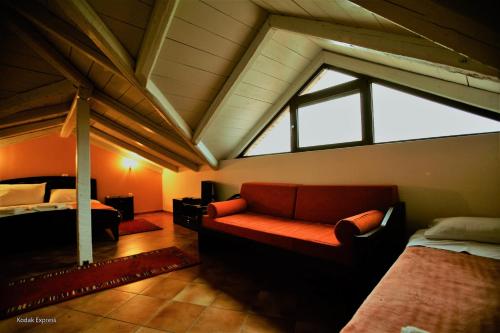 a attic room with a couch and a bed at Elikonio in Agia Anna