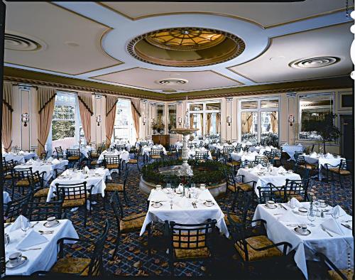 a dining room with white tables and chairs at The Broadmoor in Colorado Springs