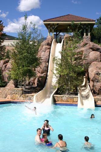 a group of people in a swimming pool with a water slide at The Broadmoor in Colorado Springs