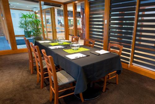 a dining room with a table with chairs and a tableablish at Copthorne Hotel Rotorua in Rotorua