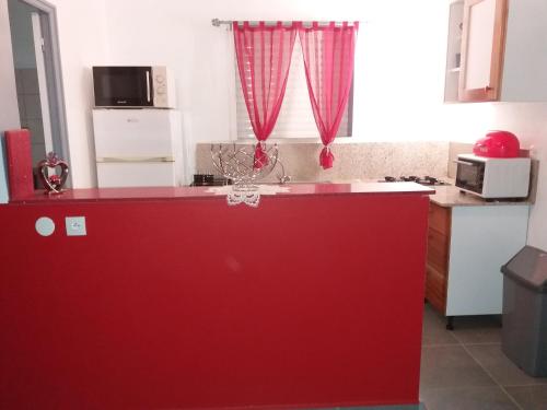 a kitchen with a red counter top in a kitchen at Villa Bananier in Lamentin