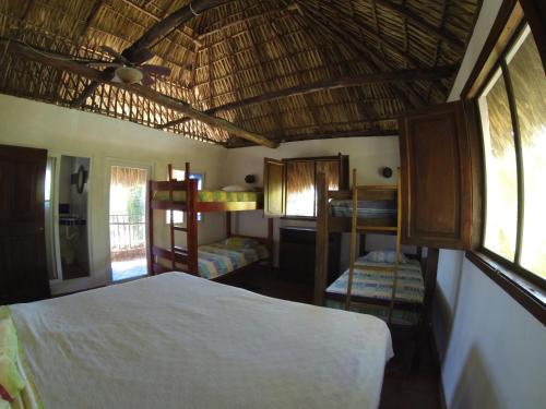 a bedroom with a bed and two bunk beds at Marbella Eco Lodge in Monterrico