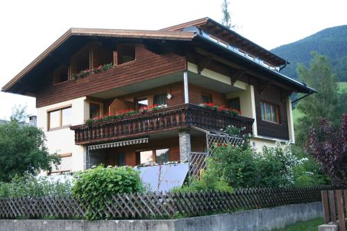 a house with a balcony with flowers on it at Haus Mitti in Heinfels