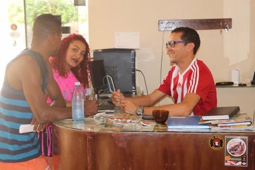 a group of three people standing around a table at Hotel Rilton in Carolina
