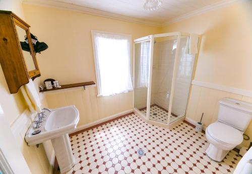 a bathroom with a shower and a toilet and a sink at Riversleigh House in Ballina