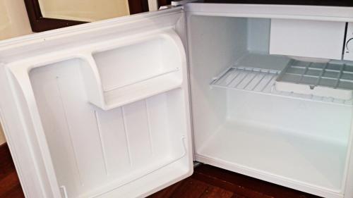 an empty white refrigerator with its door open at Hotel Sun Queen in Naha