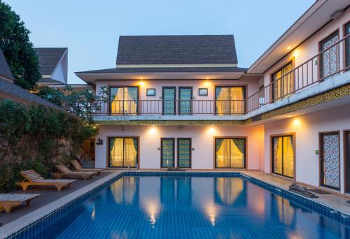 a swimming pool in front of a house at PloyKhumThong Boutique Resort in Lat Krabang