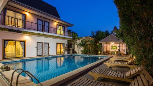 
a large swimming pool in front of a house at PloyKhumThong Boutique Resort in Lat Krabang
