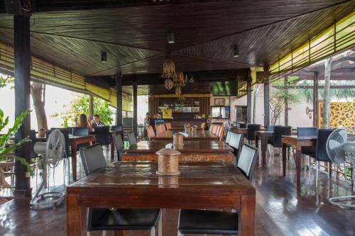 an empty restaurant with wooden tables and chairs at PloyKhumThong Boutique Resort in Lat Krabang