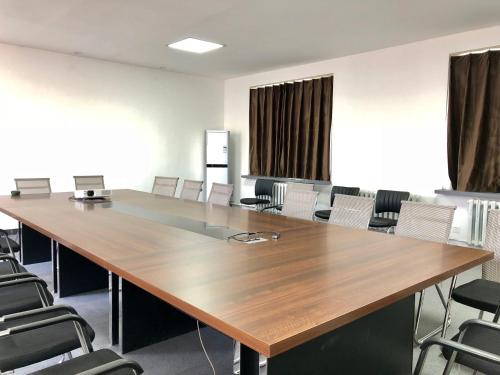a conference room with a large wooden table and chairs at Lantern Hotel in Hohhot