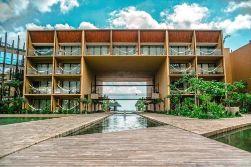 an external view of a building with a boardwalk at Hotel Xcaret Mexico All Parks All Fun Inclusive in Playa del Carmen