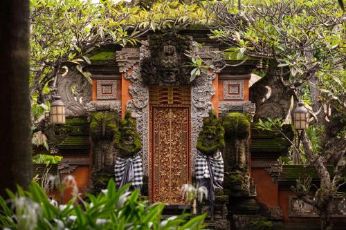 an ornate door to a house with plants at Puri Santrian Beach Resort And Spa in Sanur