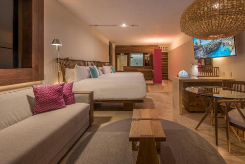 a hotel room with two beds and a couch at Hotel Xcaret Mexico All Parks All Fun Inclusive in Playa del Carmen