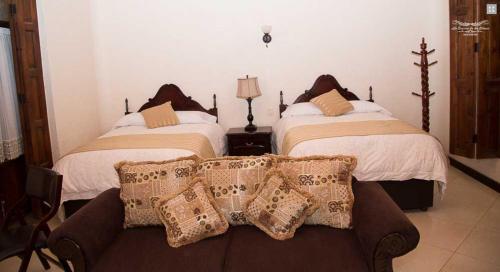 a living room with two beds and a couch with pillows at La Casona de los Gómez in Zacatlán