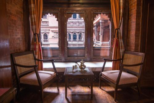 a room with two chairs and a table and a window at Kantipur Temple House in Kathmandu