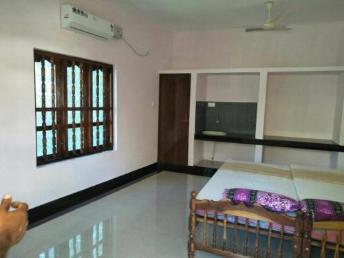 - une chambre avec un lit et une fenêtre dans l'établissement Thriphala Ayurveda Yogashram, à Trivandrum