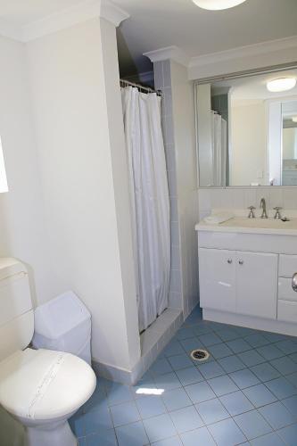 a bathroom with a toilet and a sink and a mirror at Darcy Arms Hotel Motel in Gold Coast