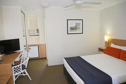 a hotel room with a bed and a desk and a television at Darcy Arms Hotel Motel in Gold Coast